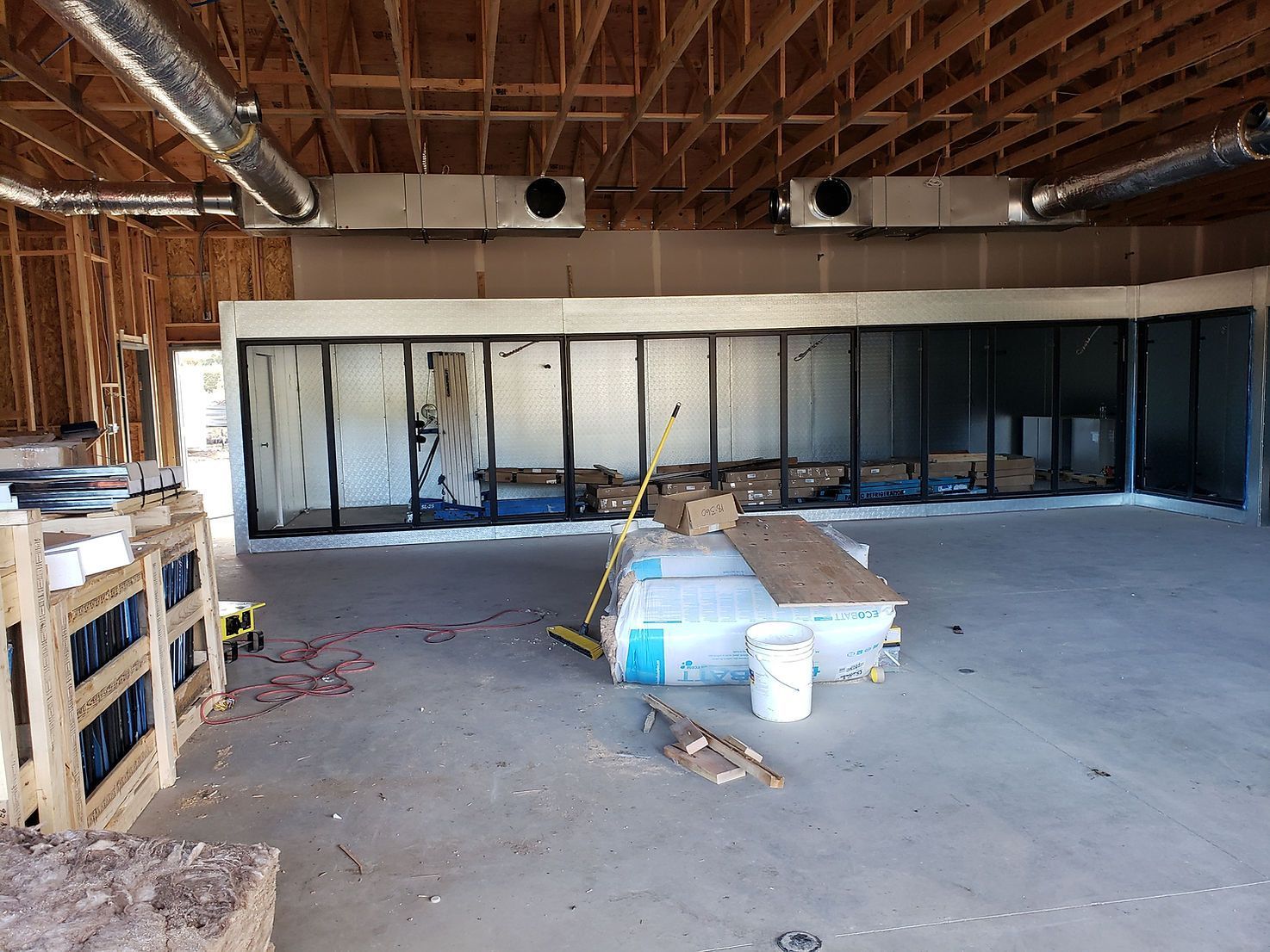A large room in a building under construction with a lot of boxes on the floor.