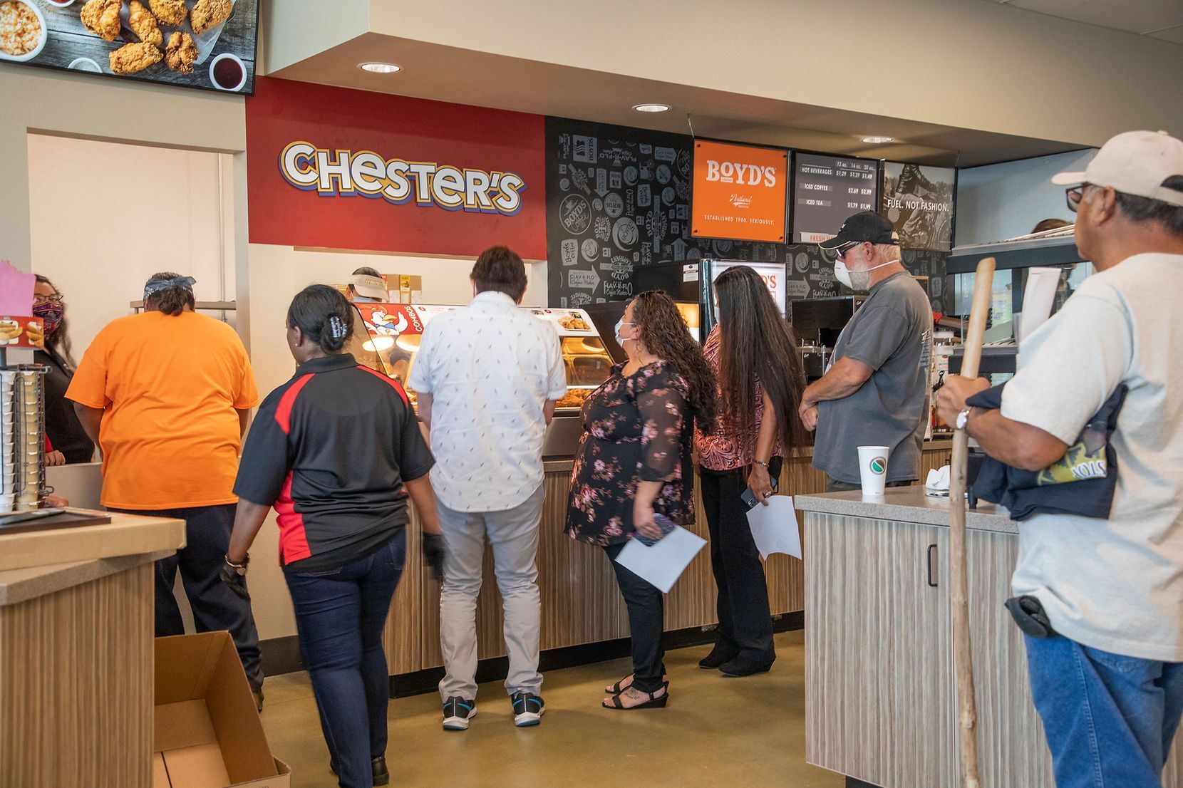 A group of people are standing in line at a restaurant.