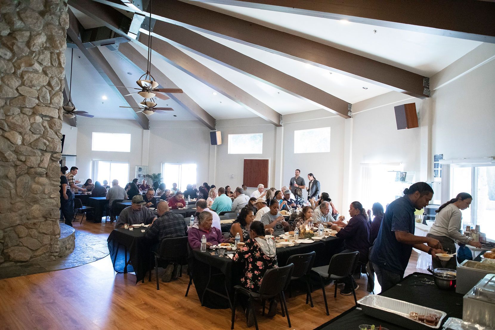 A large group of people are sitting at tables in a large room.