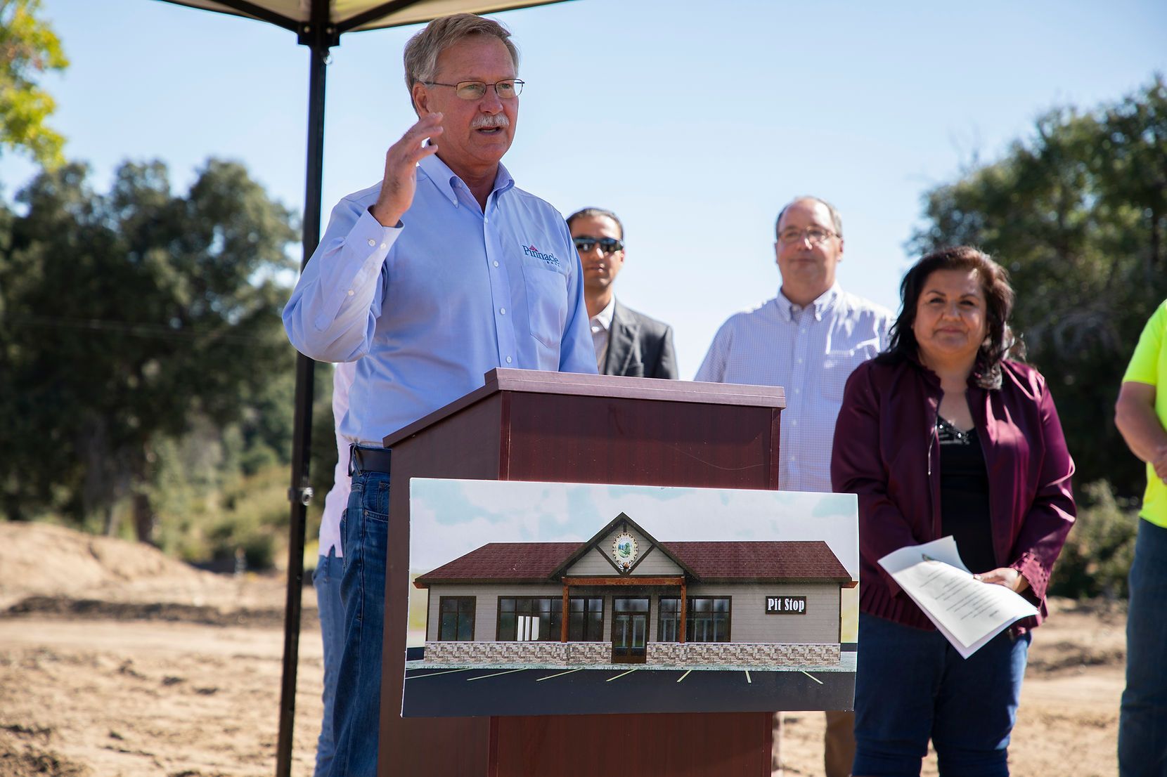 A man is standing at a podium with a picture of a house on it.