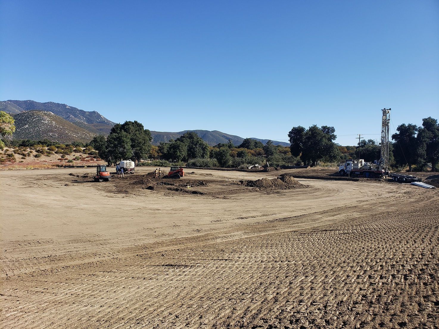 A large dirt field with a lot of dirt and trees in the background.