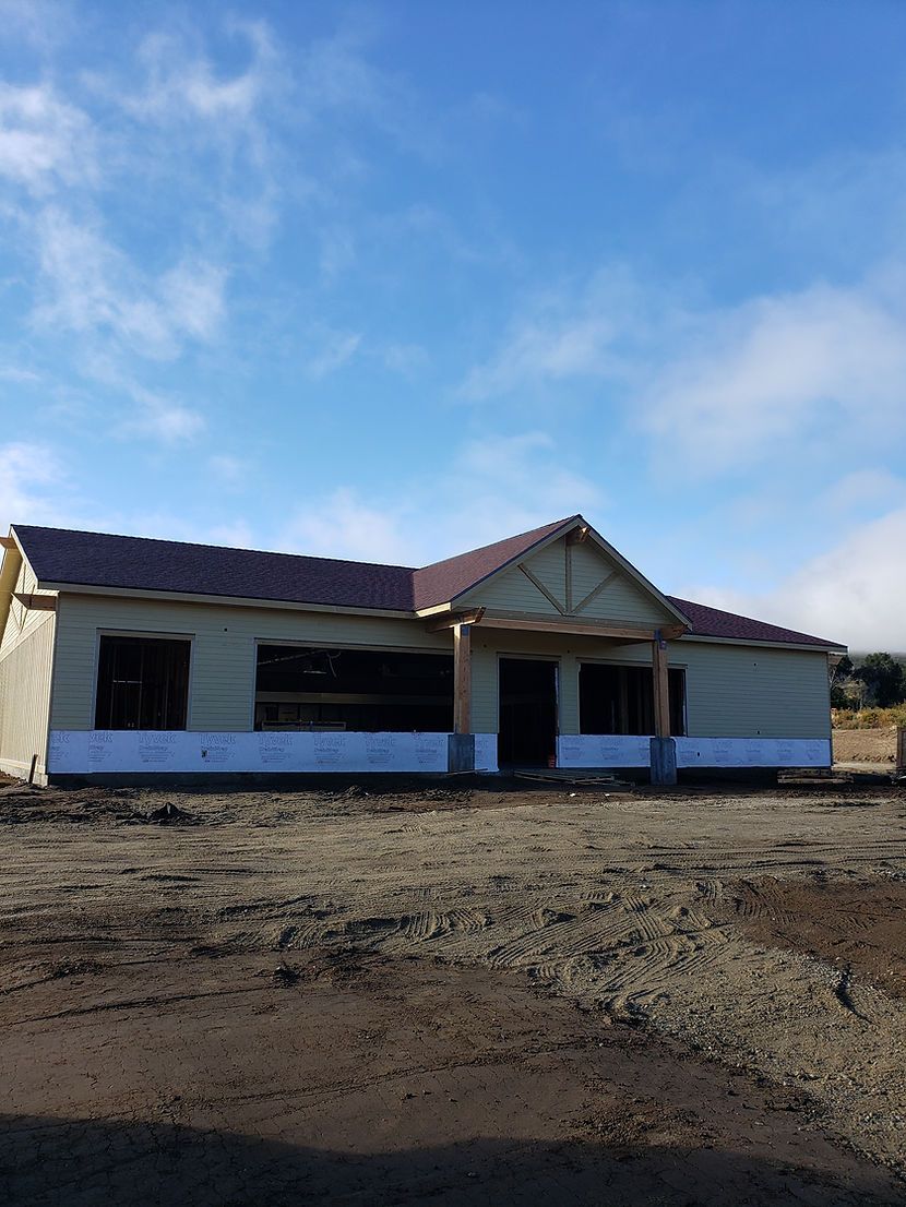 A house is being built in the middle of a dirt field.