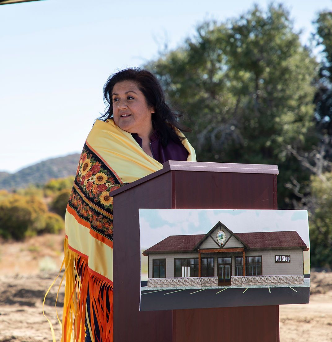 A woman stands behind a podium with a picture of a house on it