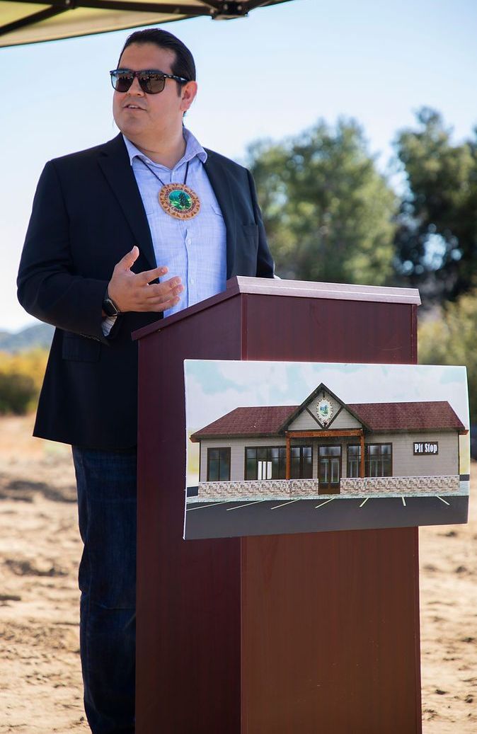 A man in a suit is standing at a podium with a picture of a house on it.