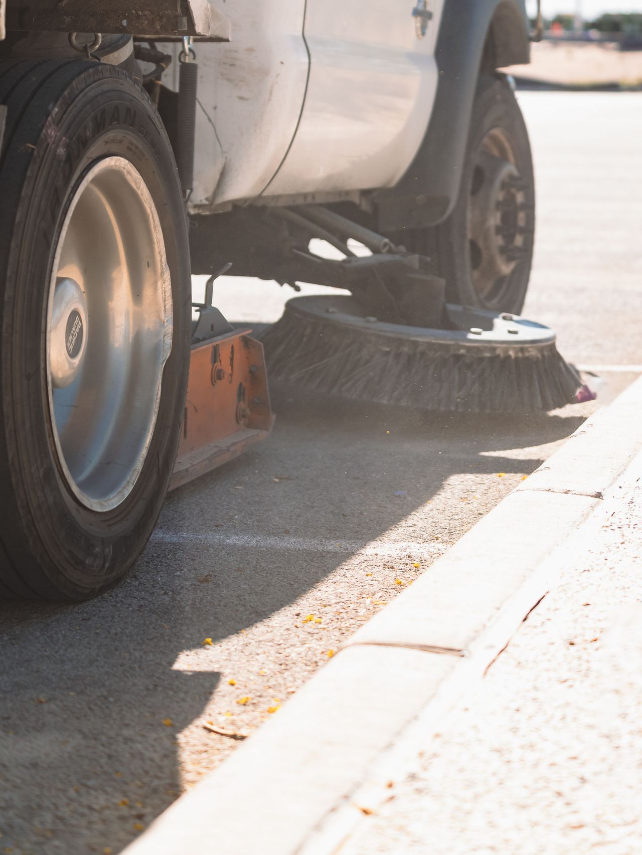 Sweep It Clean sweeper truck at a parking lot curb