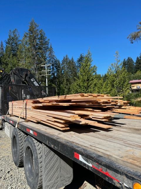 A truck with a stack of wood on the back of it