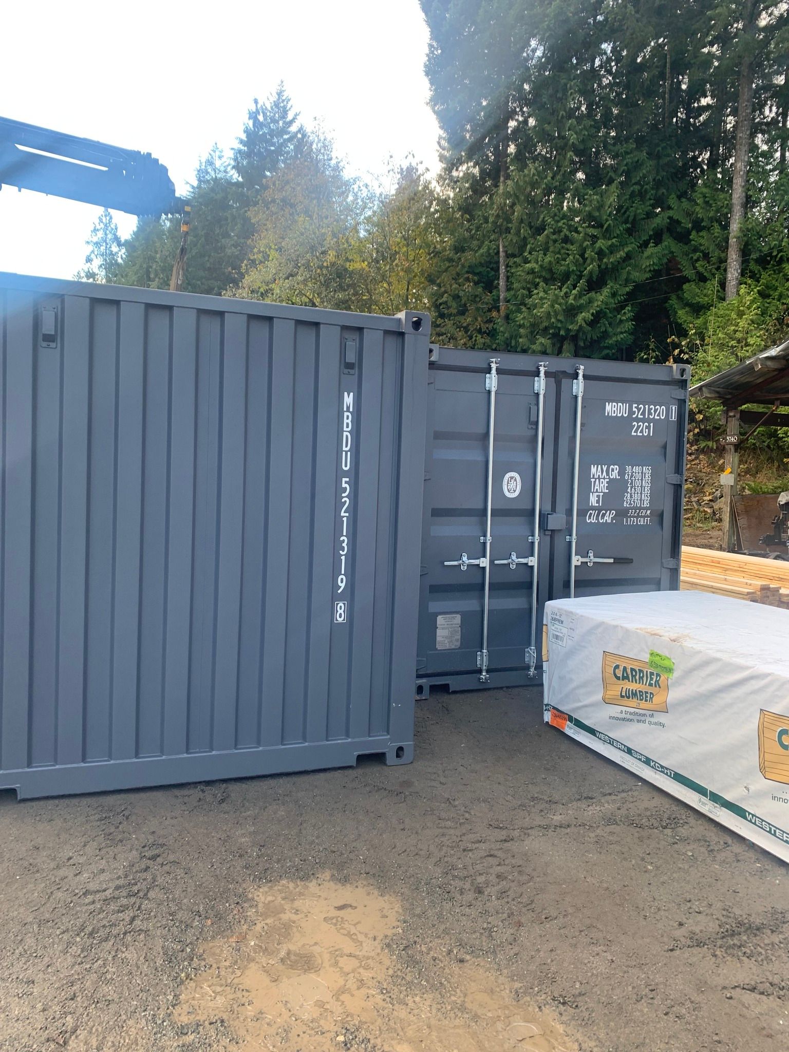 Two shipping containers are sitting next to each other in a parking lot.