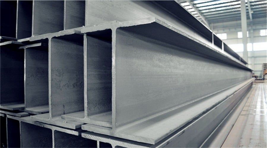 A row of steel beams are stacked on top of each other in a warehouse.