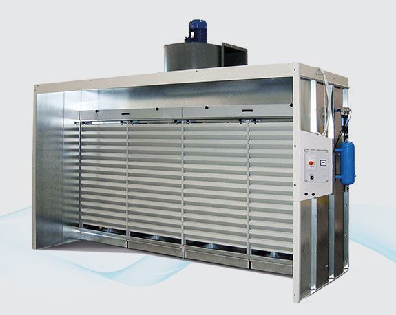Large industrial machine with silver louvered panels and blue motor on top, shown in a studio setting