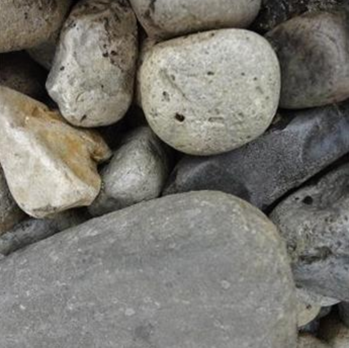 A collection of smooth, multi-colored river stones of varying sizes and gray, beige, and tan tones.