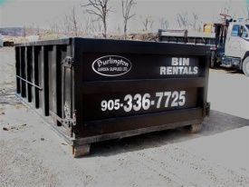 A black dumpster for rent, labeled