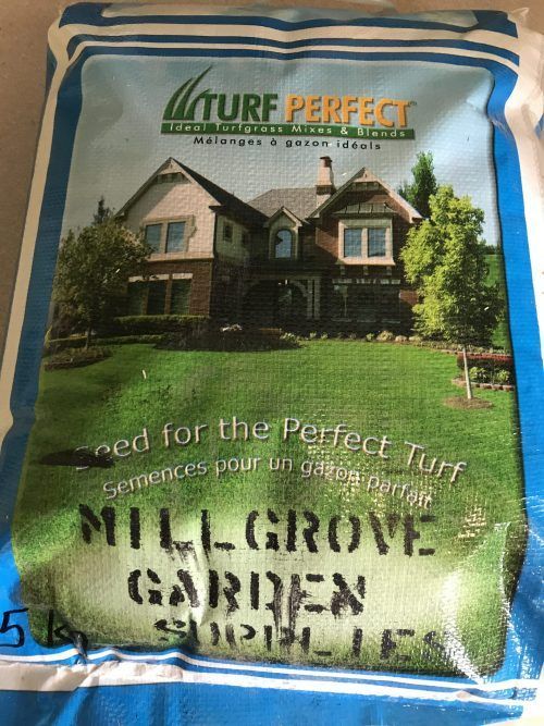 A 5kg bag of Turf Perfect grass seed with a picture of a house and lawn, labeled Millgrove Garden Supplies.