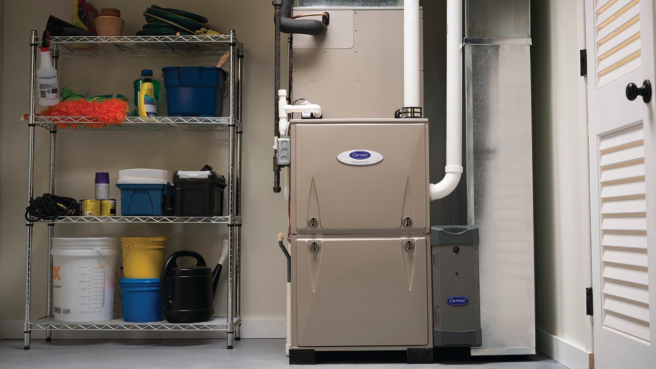 A furnace in a utility room next to a storage shelf. The room is painted light beige.