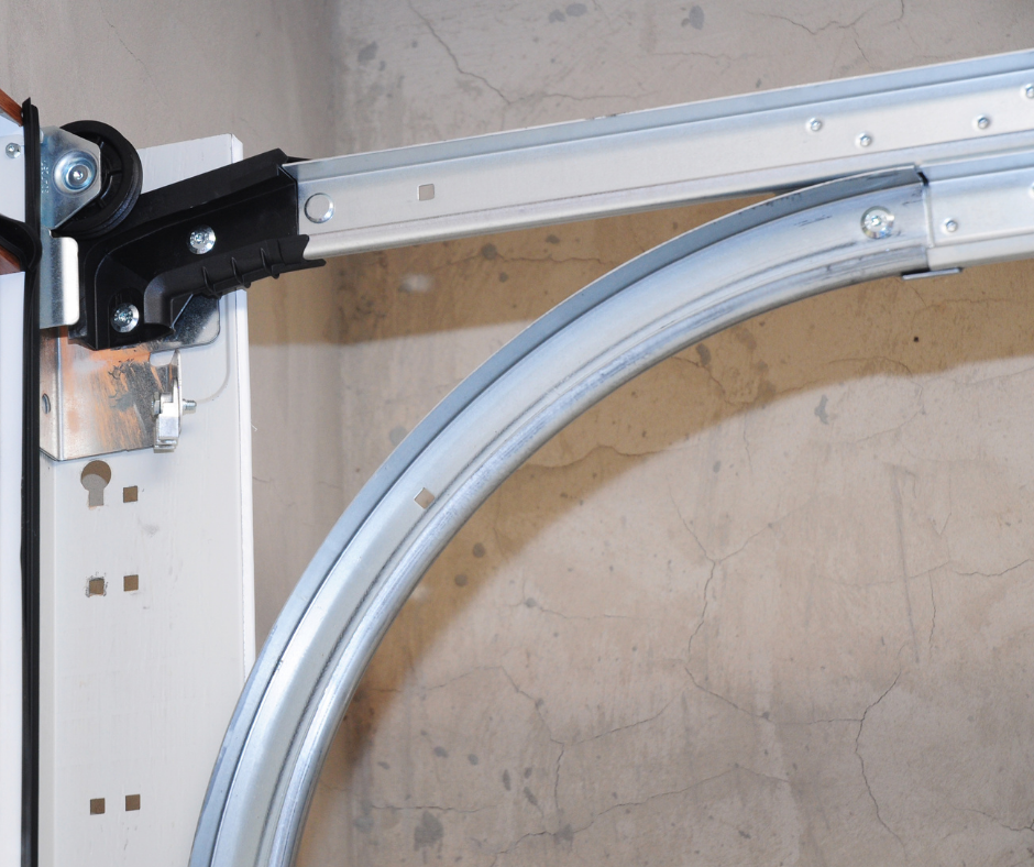 Garage door track with curved metal rail and opener mechanism mounted on the left.