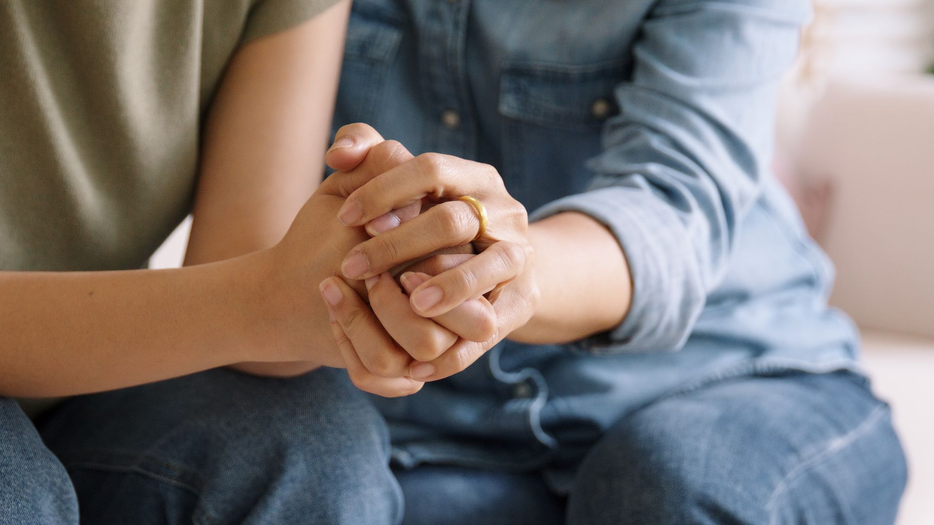 Hands of several people piled on top of each other in a symbol of teamwork and unity.