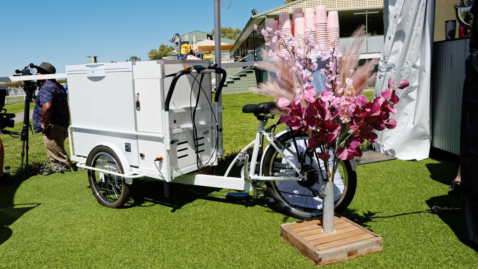 A bicycle with a trailer attached to it is parked in the grass.