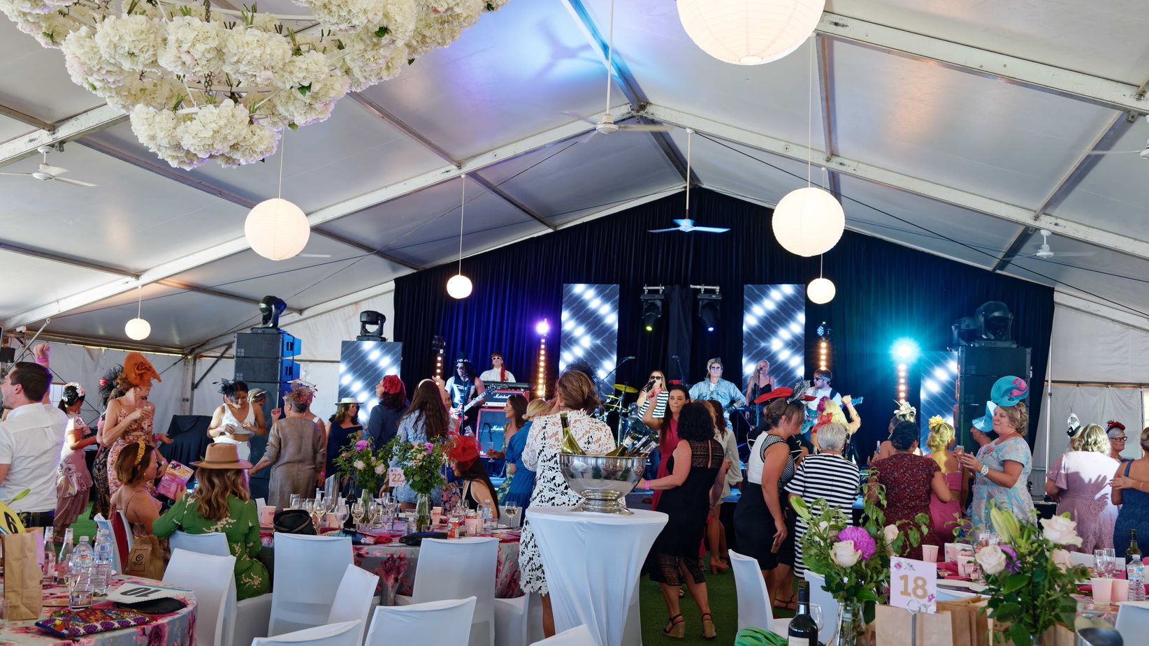 A large group of people are standing in a large tent.