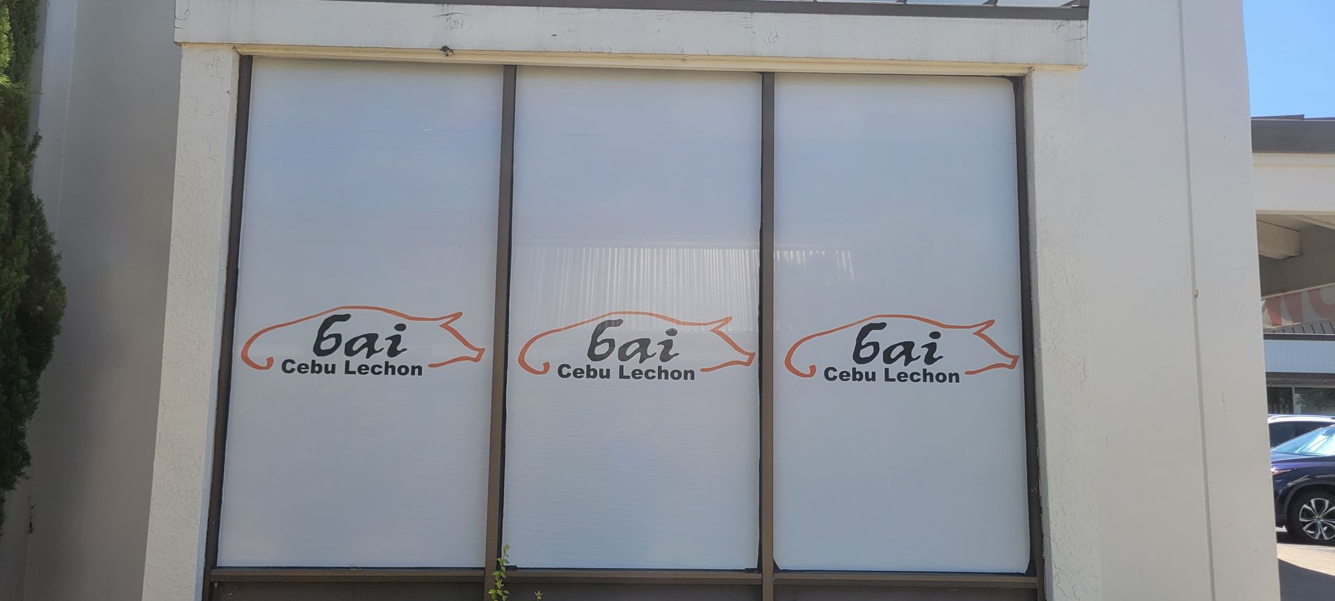 Glass storefront with three doors and white “dot” logos on frosted panels