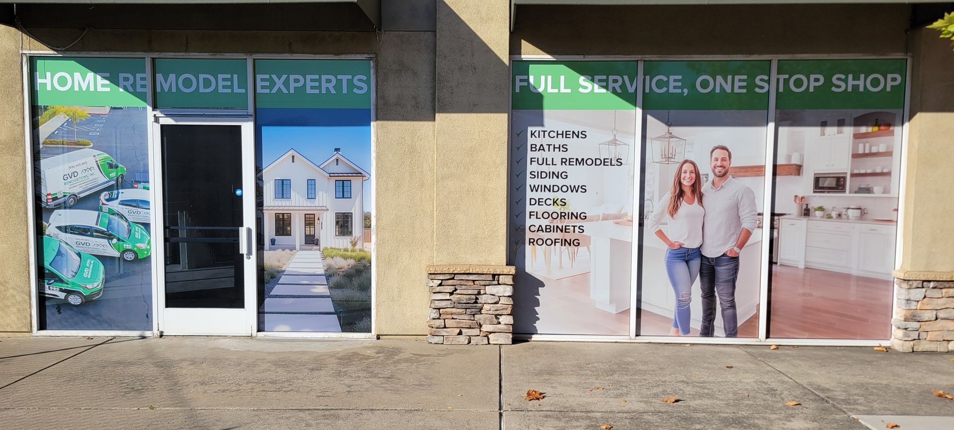 Storefront with green signage, doors, and window posters for home models and full-service shop