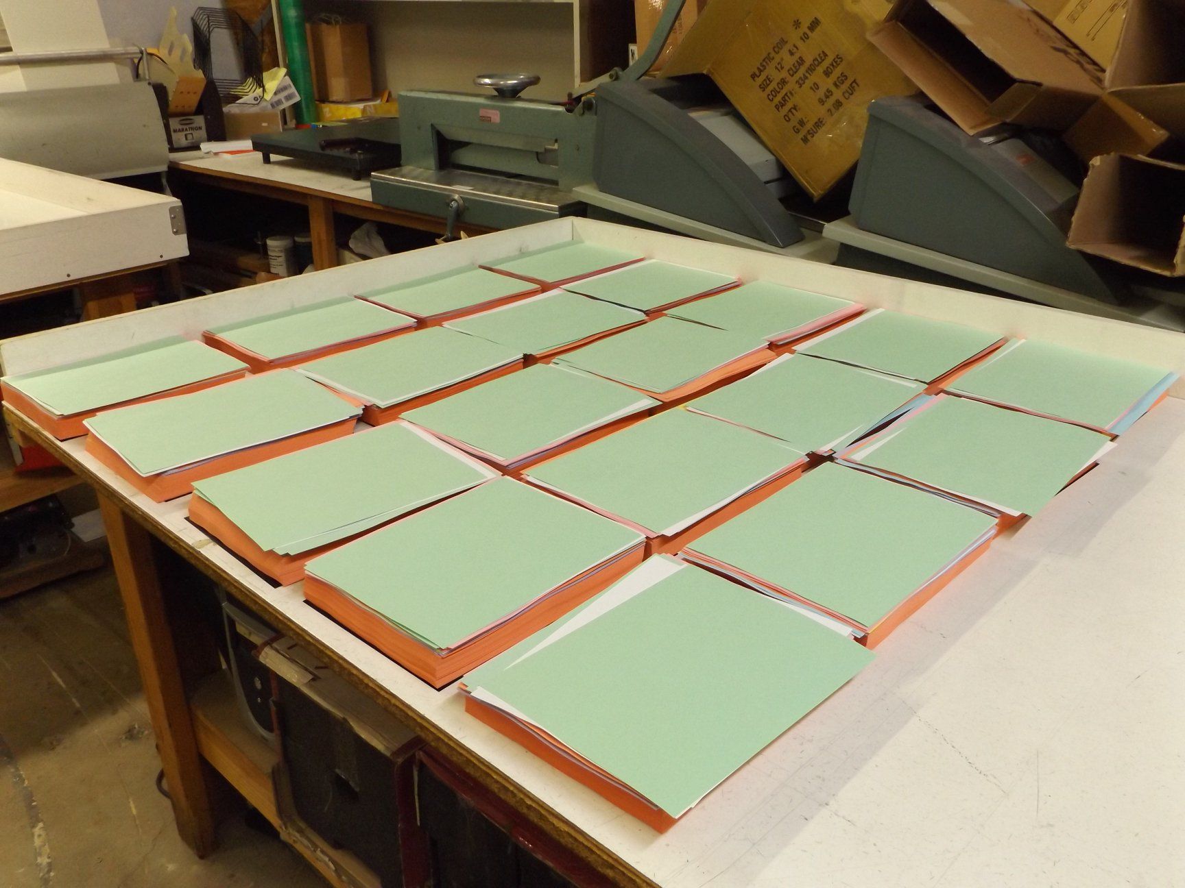 Green and orange rectangular objects arranged on a white table in a workshop setting.