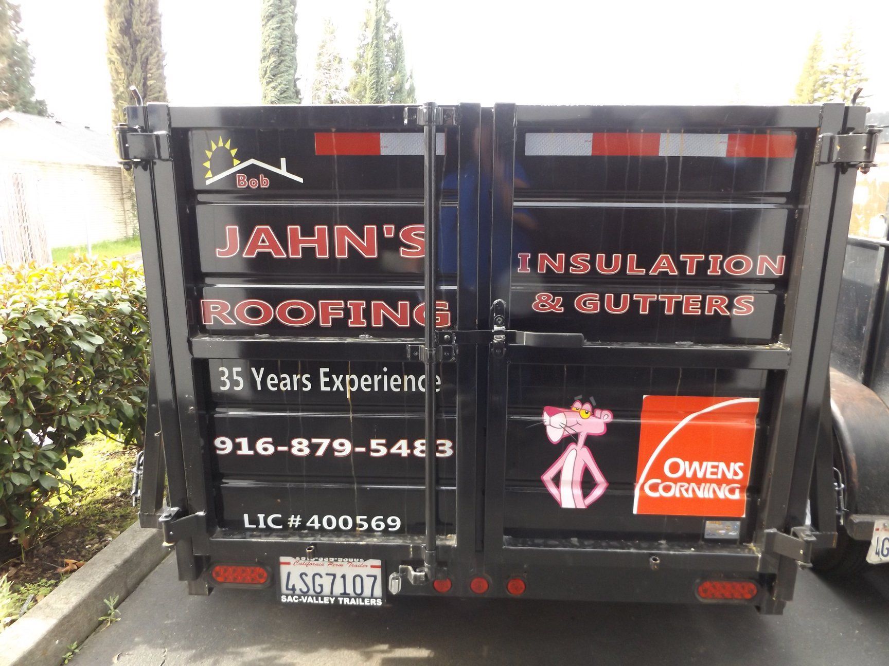 Black trailer with roofing company logo: 