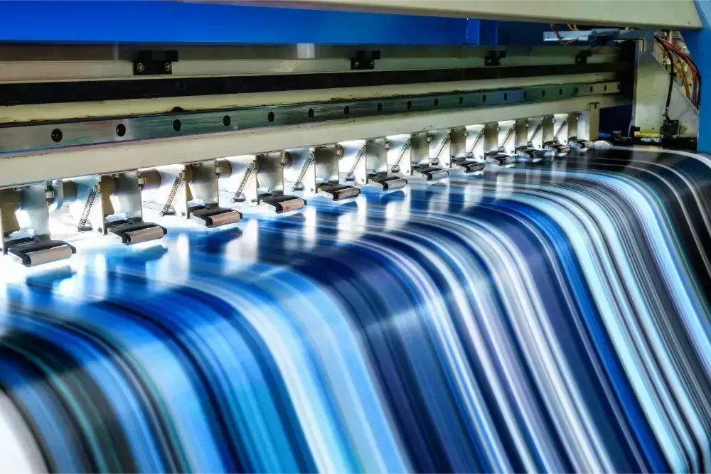 Industrial printer producing blue striped fabric or paper sheets