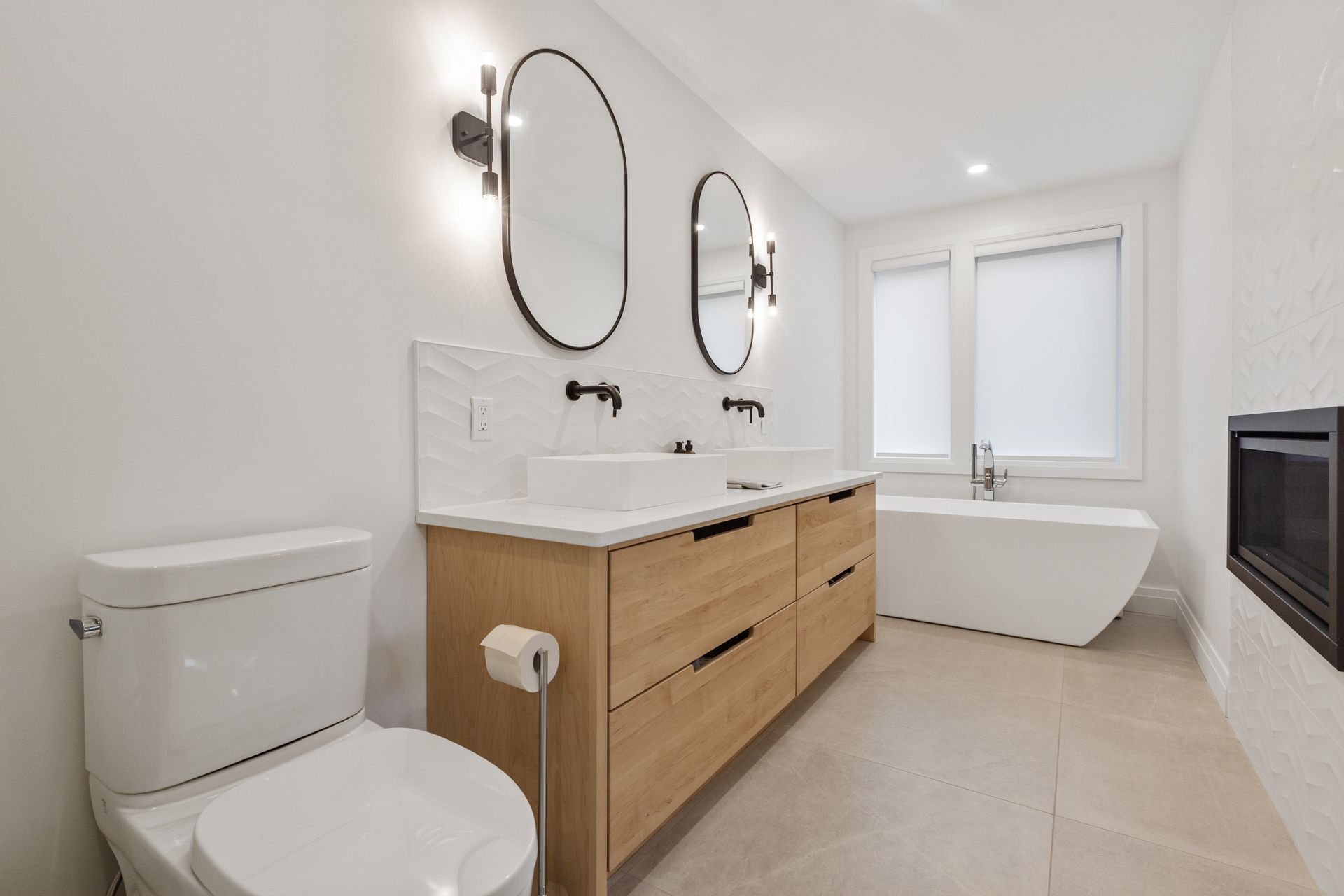 A bathroom with two sinks , a toilet , and a bathtub.
