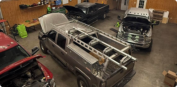 Several classic cars in a garage, | Stack’d Diesel Specialists