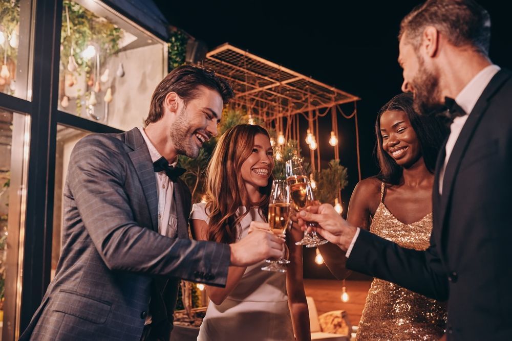 A group of people are toasting with wine glasses at a party.