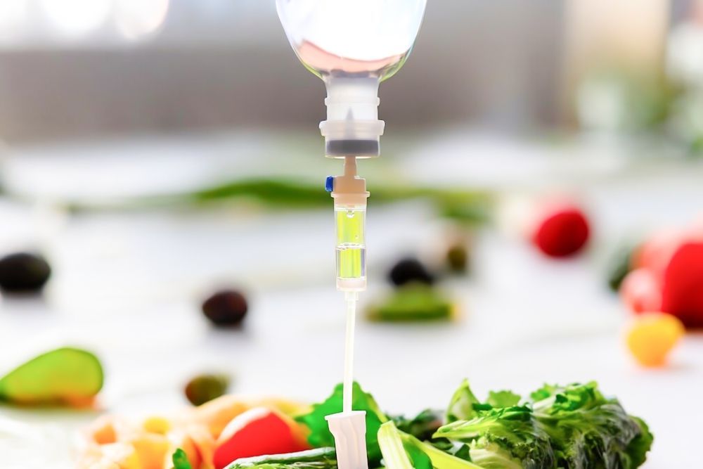 A bottle of liquid is being poured into a plate of vegetables.