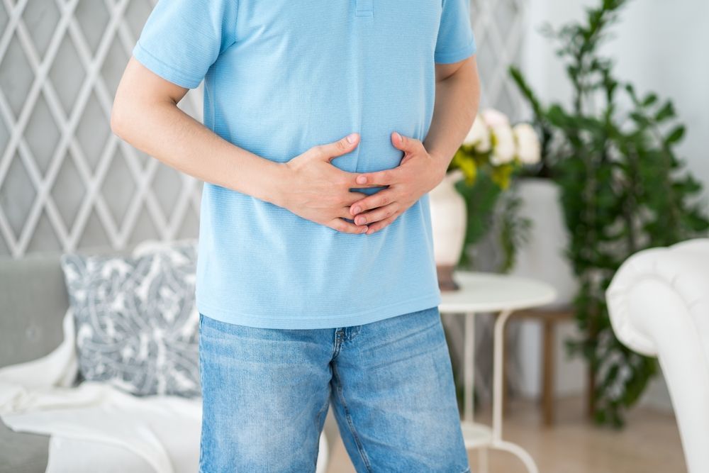 Person holding their stomach for digestive comfort