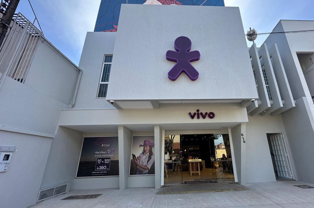 Fachada da loja Vivo com um logotipo roxo acima da entrada em um prédio branco.
