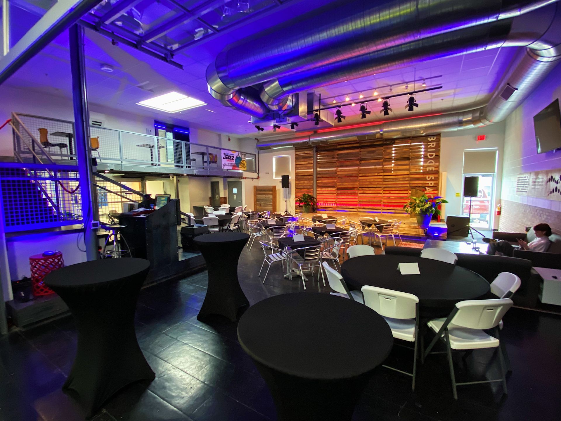 lees summit event space with black table cloths chairs and lighting