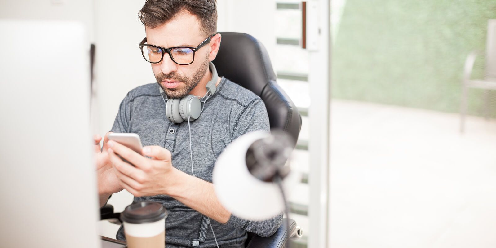 man checking his phone and getting distracted from his work