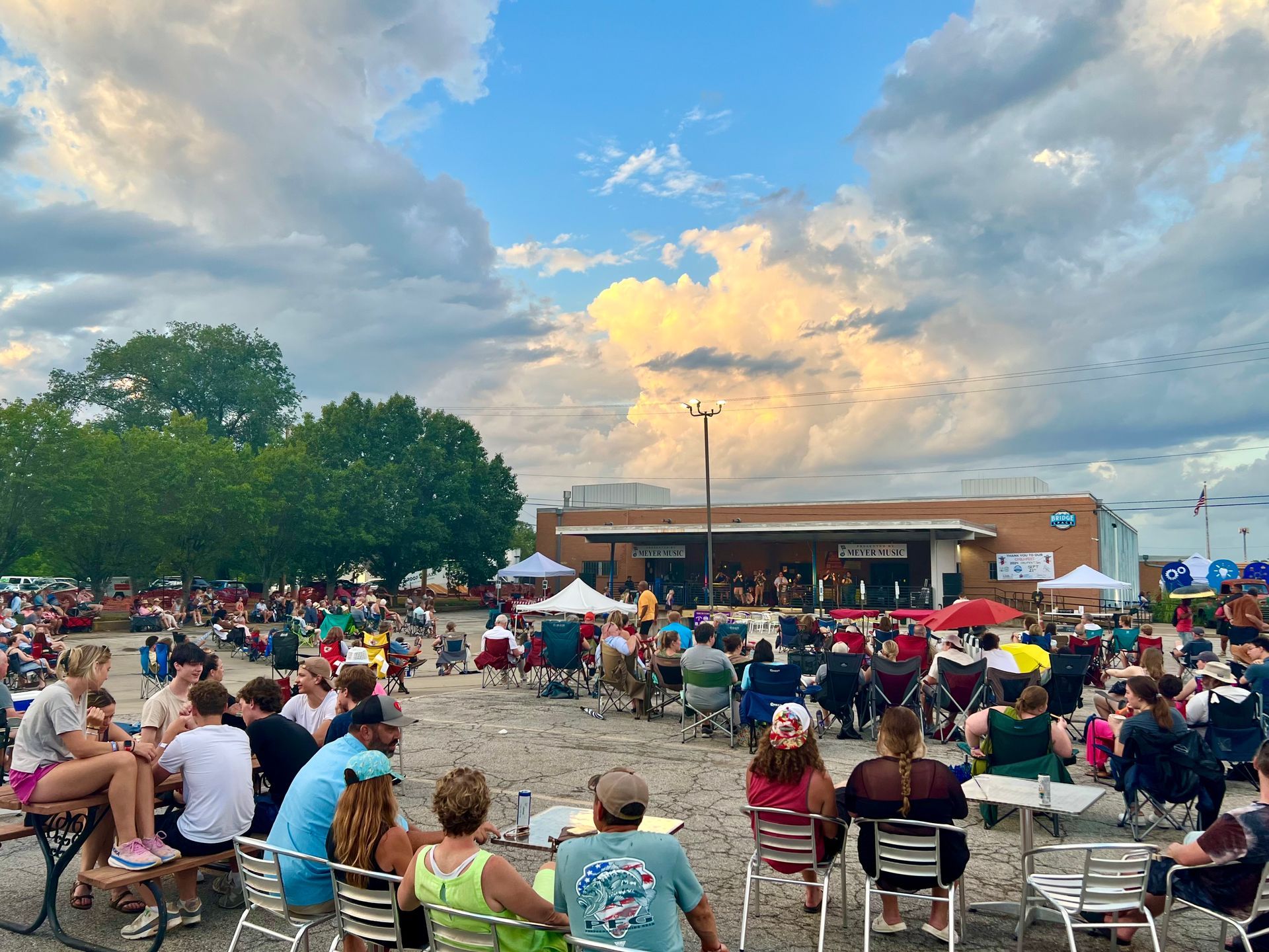 large crowd of people sitting down in chairs and standing
