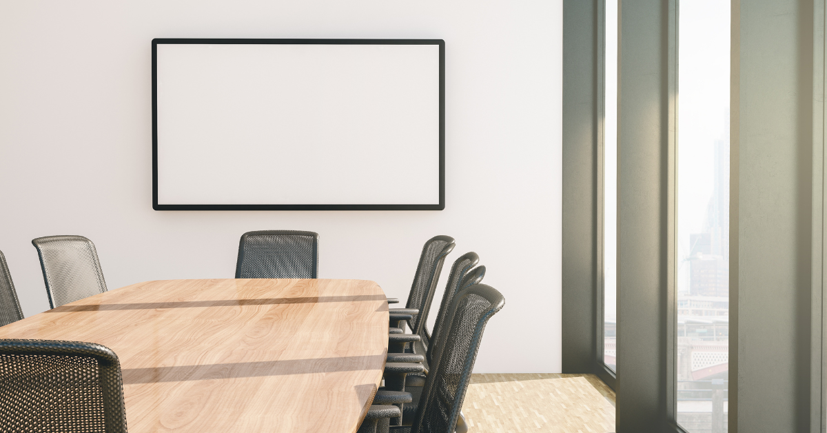 Modern conference room with wooden table, ergonomic mesh chairs, large HDTV screen on walls