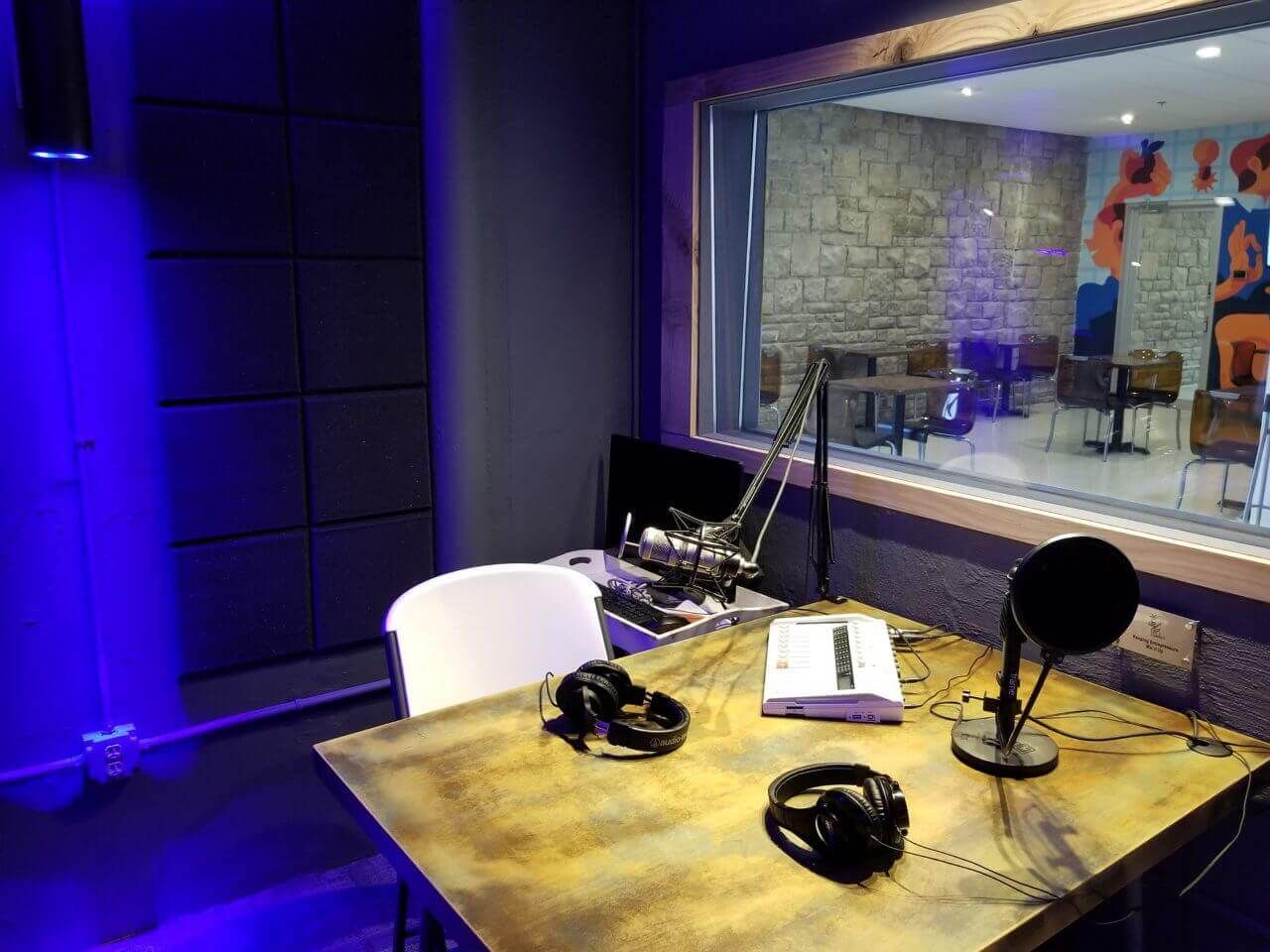 podcast studio with recoding gear and a large window