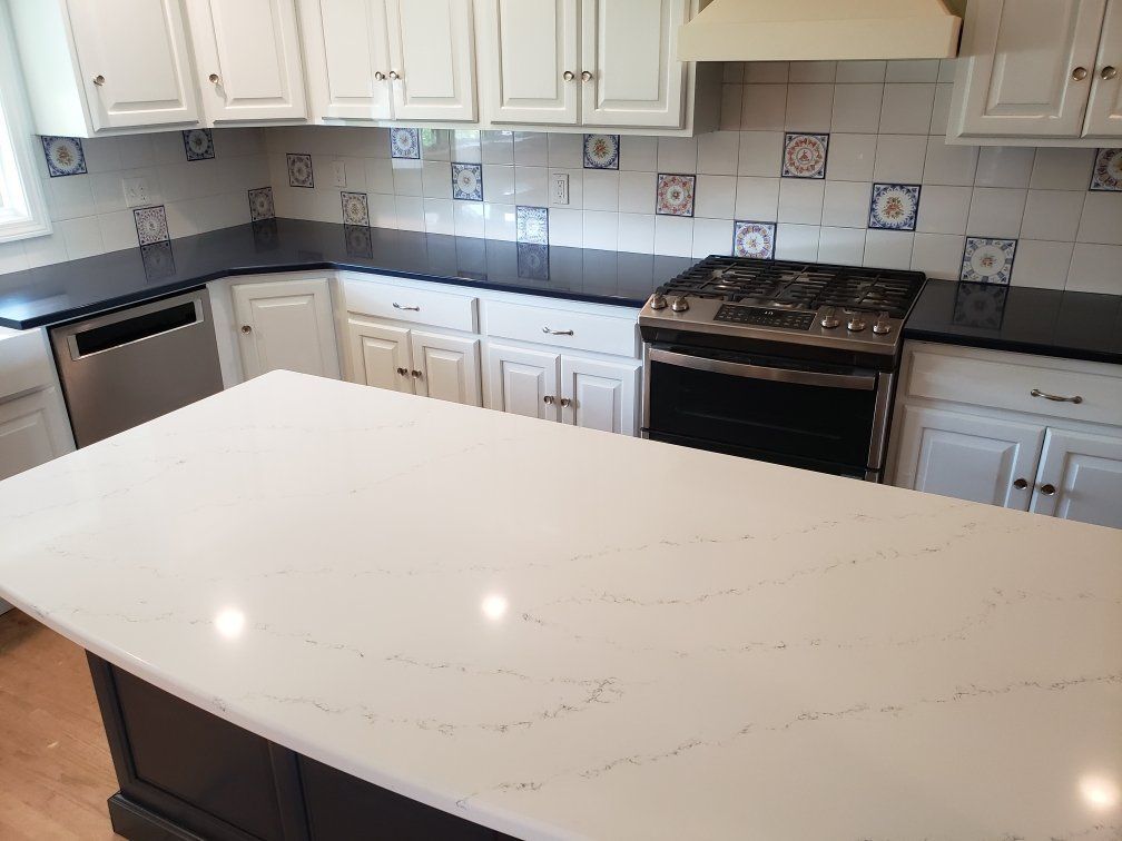 a kitchen with black counter tops and white cabinets