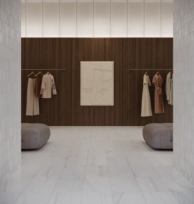 a showroom with clothes hanging on racks and a painting on the wall .