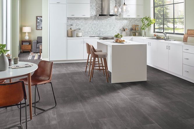 a kitchen with a table and chairs and a gray floor .