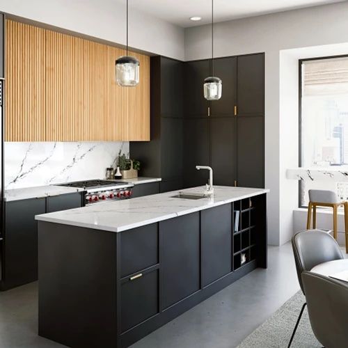 a kitchen with black cabinets , white counter tops , and a large island .