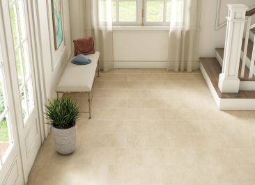 a hallway with a bench and stairs and a potted plant on the floor .