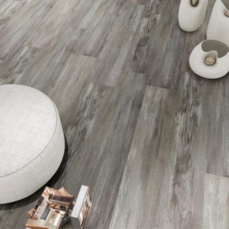 a living room with a wooden floor and a white ottoman .