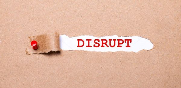 A piece of torn paper with the word disrupt written on it.