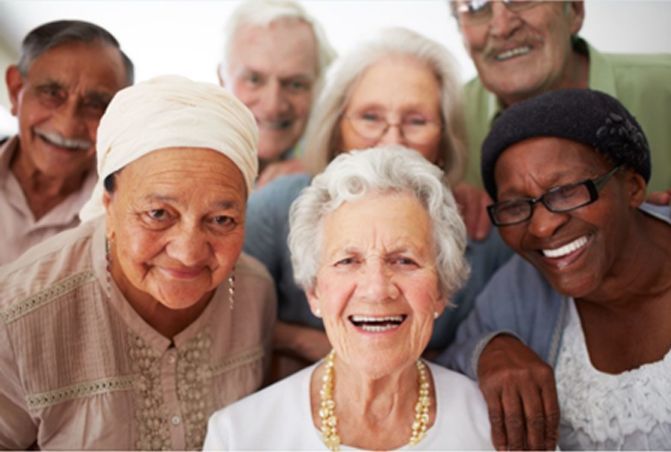 A group of elderly people are posing for a picture and smiling.