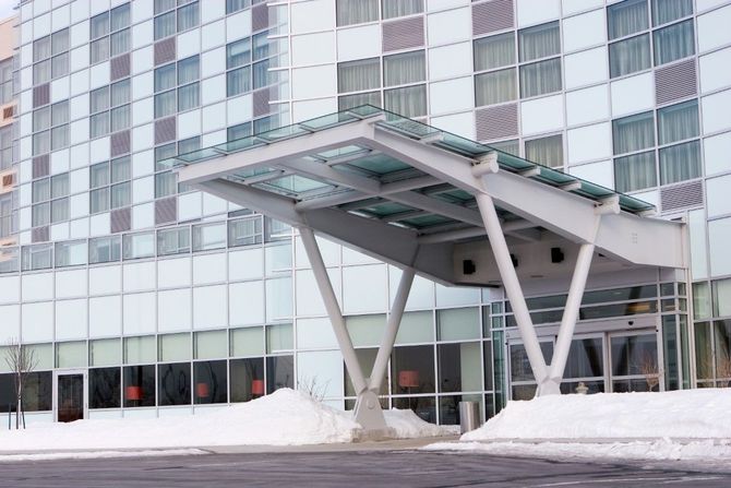 Modern building entrance with a glass canopy and snow on the ground