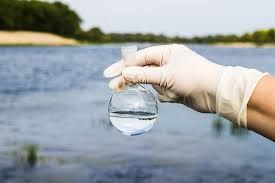 Technician collecting well water sample outside Arizona home for professional testing