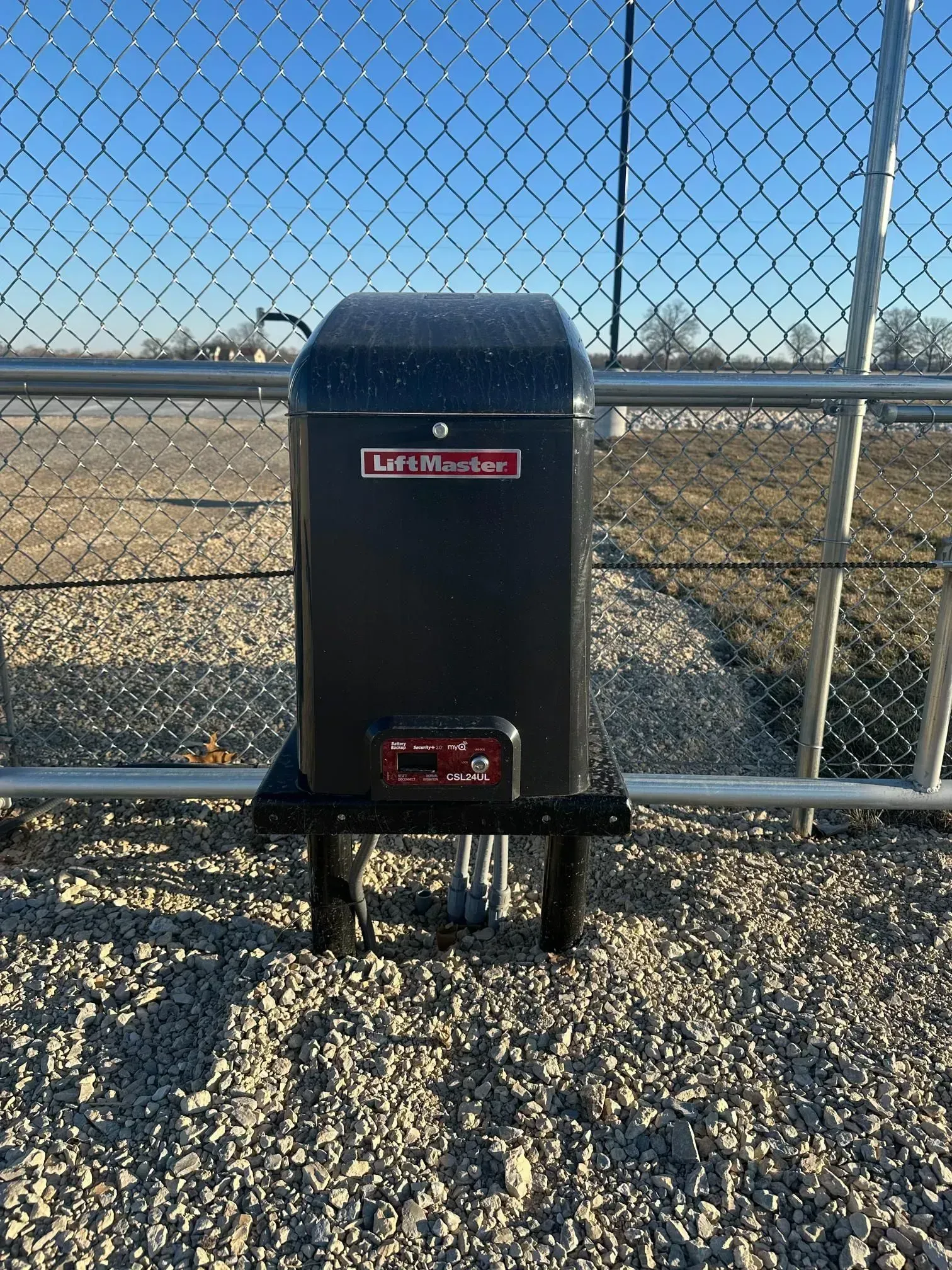 A LiftMaster automatic gate operator mounted to a fence at a secure trailer storage facility.