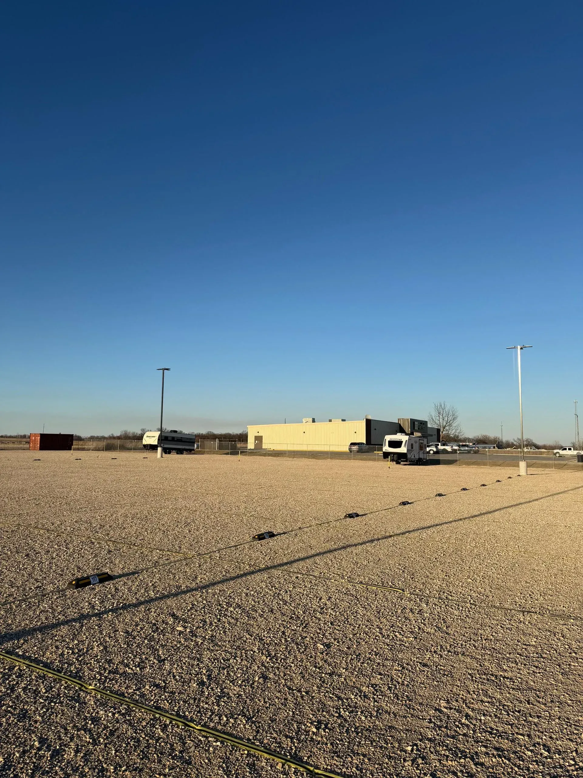 Gravel RV storage facility with wide driving aisles.