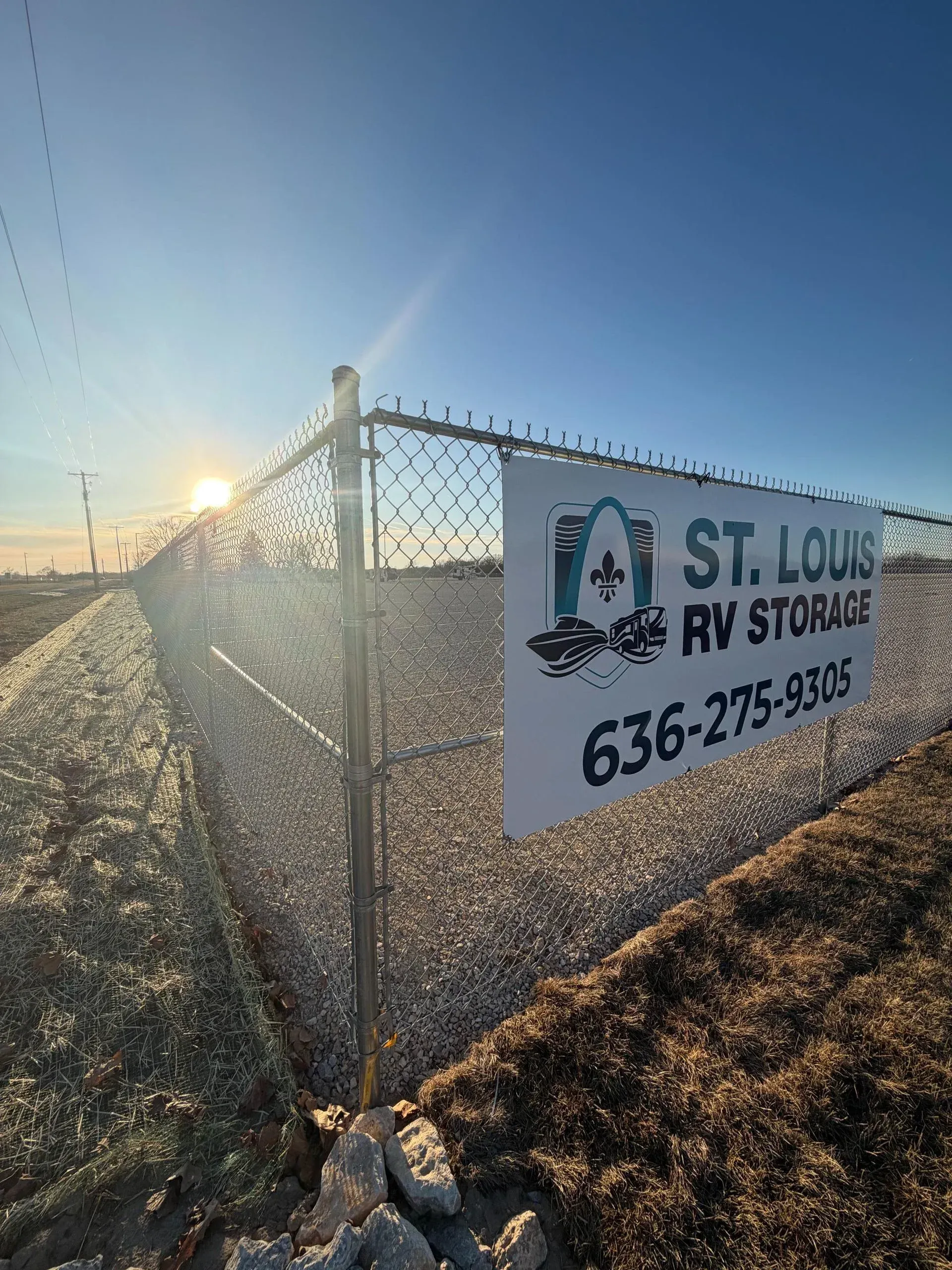 Fenced perimeter of the St. Louis RV Storage facility with business signage.